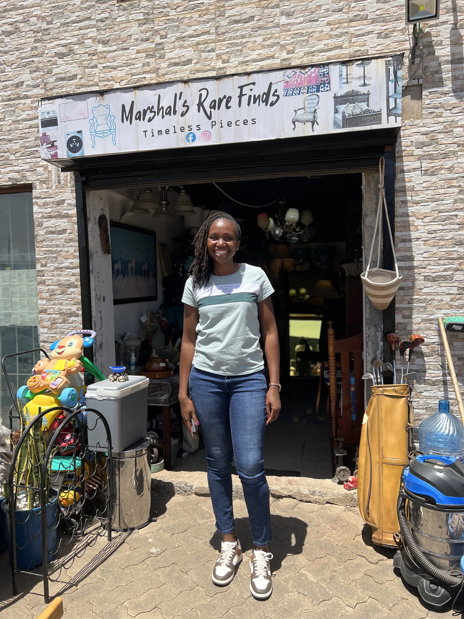 A woman stands in front of a home decor shop.